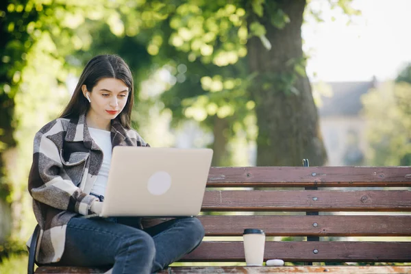 Young student watching lesson online and studying from park. Woman college university student using laptop computer. Studying working with pc technology online education concept. — Stock Photo, Image