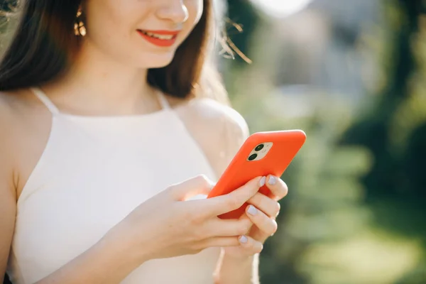 Vrouw met mobiele telefoon in het park. — Stockfoto