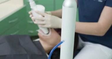 Ultraviyole lamba kullanarak diş beyazlatma. Diş hekimi ultraviyole lambayla diş beyazlatma işlemi yapıyor. Diş bakımı ve diş hekimliği kavramı.