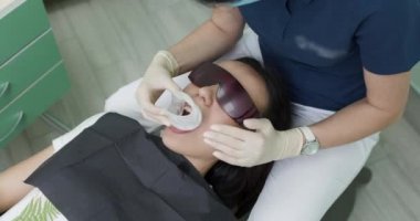 Çekici bir kadın güzel, sağlıklı bir gülümseme estetik dişçiliğiyle gülümsüyor. Diş beyazlatma prosedürü. Beyazlatma işleminden sonra güzel bir gülümseme. Dişçi muayenehanesindeki kadın.