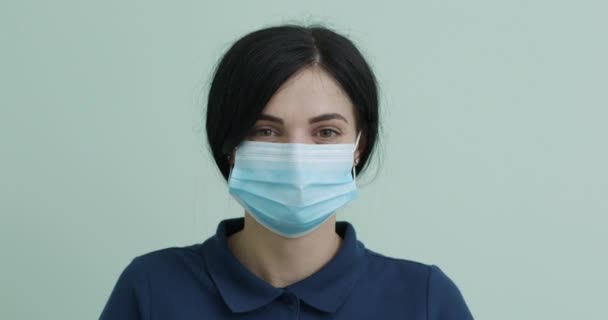 Koncepcja ochrony zdrowia wirusa korony. Młoda kobieta w masce medycznej. Kobieta oddycha głęboko i patrzy w kamerę. — Wideo stockowe