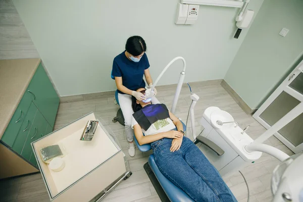 Dentista fazendo procedimento de clareamento dos dentes com lâmpada ultravioleta. Conceito de cuidados dentários e odontologia. Levou clareamento dos dentes. Raios ultravioletas. lâmpada para dentes esmalte branqueamento. Belo sorriso — Fotografia de Stock
