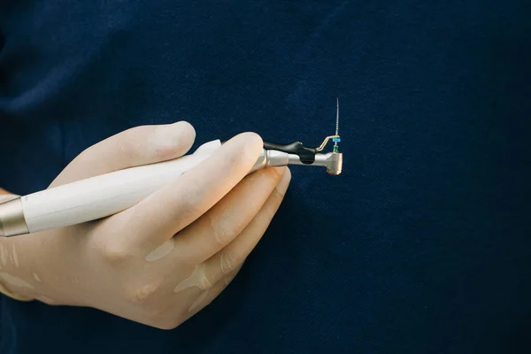 Fechar a mão do dentista com uma ferramenta especial para remover o nervo do dente. Ferramentas ortopédicas do dentista. Cirurgia dos instrumentos utilizados na implantologia dentária — Fotografia de Stock