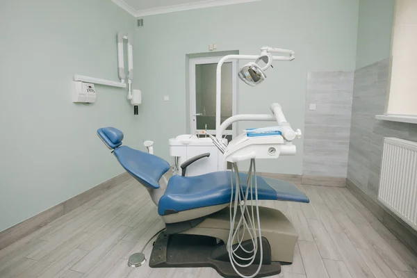 现代牙科诊所牙医用的牙椅和其他配件，蓝光，医疗灯。牙科医生办公室、牙卫生、牙科讲座 — 图库照片