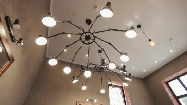 Deux grands lustres dans un salon de coiffure. Miroirs éclairés dans le salon de coiffure. Salon de coiffure avec deux grands lustres dans le salon de beauté.