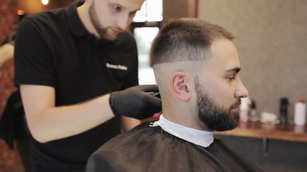 Barber coupe barbu mans cheveux avec une tondeuse dans le salon de coiffure. Coiffure masculine et coupe de cheveux dans le salon. Coiffeur faisant la coupe de cheveux dans le salon de coiffure. — Video