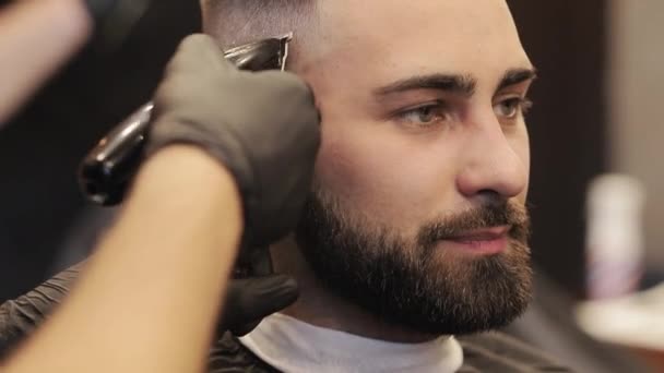 Coiffeur avec tondeuse faisant la coupe de cheveux au salon de coiffure ou salon de coiffure. Concept beauté, coiffure et personnes. — Video