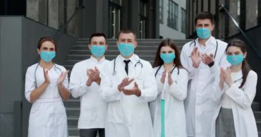 Coronavirus 'la mücadele eden hastane sağlık personeli, destekleri için halkı ve polis memurlarını alkışlıyor. Corona Virüsü ve Sağlık Hizmetleri Konsepti. Yüz maskeli doktorlar.