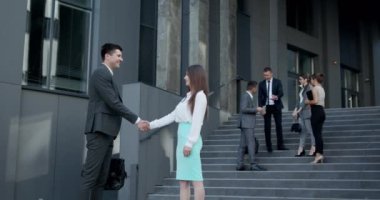 Dostça el sıkışan adam ve kadın. İki İş Adamının Dışarıda Buluşması. Birbirinizi selamlayan insanlar. El sıkışma