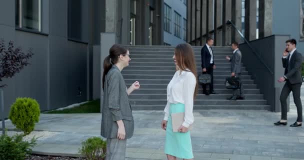 Две успешные бизнесвумен стоят на улице и разговаривают, обсуждая рабочий проект. Концепция корпоративного обсуждения и командной работы. — стоковое видео