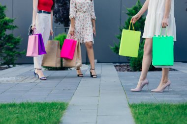 Alışveriş merkezi. Alışveriş yaparken elinde bir sürü renkli çanta tutan mutlu kadınlar. Tüketim, alışveriş, yaşam tarzı konsepti.