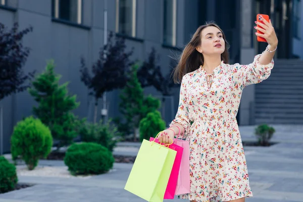 Happy lány szelfit készít mobil okostelefonnal a szabadban. Társadalmi befolyásos nő, aki jól érzi magát bevásárlás közben. Az új generációs ifjúsági életmód koncepciója. — Stock Fotó