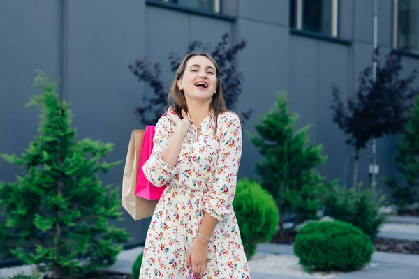 Alışveriş torbası tutan kadın kameraya bakıyor. Güzel beyaz tenli alışverişçi mutlu gülümsüyor. — Stok fotoğraf
