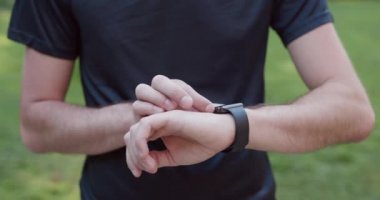 Genç adam yeni bir akıllı saat deniyor. Akıllı saat. Akıllı Saat kullanan adam. Yakın çekim..