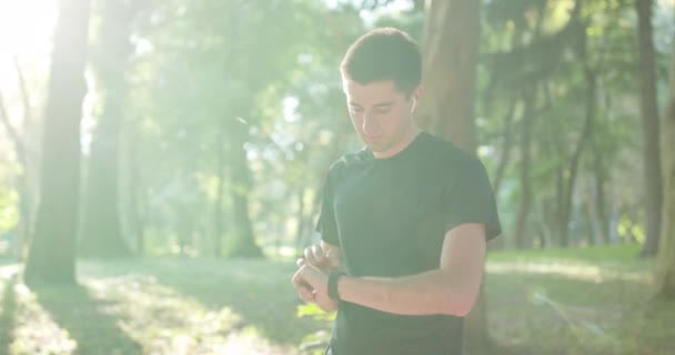 Man runner using smart watch. Handsome guy tracking result after workout. Portrait of fitness man checking result. Sport man looking smart watch — Stock Video