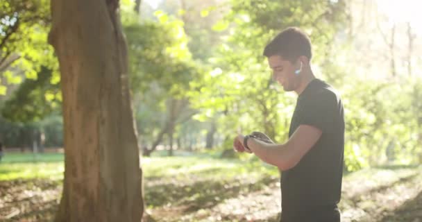액티브 러너는 스마트 워치로 심장 박동수를 확인 합니다. 건강 한 백인 남자가 달리는 동안 건강 한 트래커를 사용하는 초상화 — 비디오