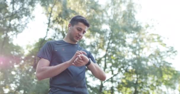 Blanke man in sportuniform met behulp van smartwatch om snelheid, afstand, hartslag zorg over fysieke gezondheid te meten. Futuristische technologie. Zwijg. — Stockvideo