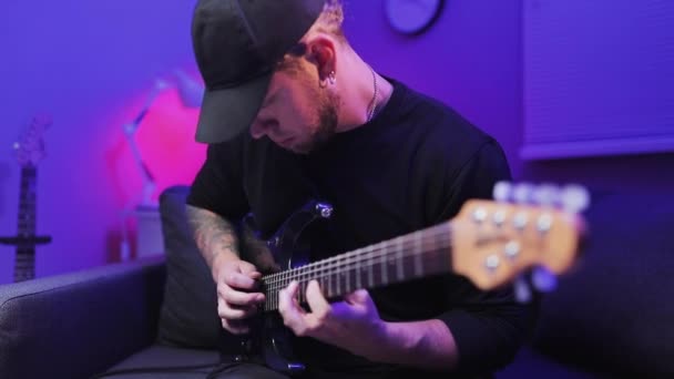 Handheld close-up shot van de virtuoze gitarist speelt de elektrische gitaar en beweegt snel vingers in de hals van de gitaar. — Stockvideo