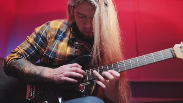 Een virtuoze gitarist die een elektrische gitaar speelt met LED lampjes — Stockvideo