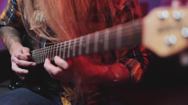 Professionele Rock gitarist speelt riffs op elektrische gitaar thuis studio met LED-verlichting. Een gitarist speelt een rock riff met zijn gitaar — Stockvideo