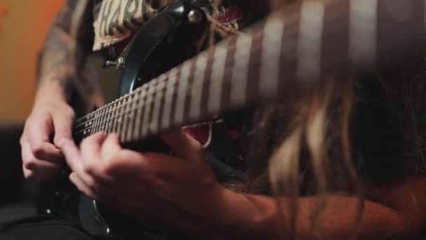 Close-up van gitaarsnaren en hals. Gitarist rock, metal van prachtige achtsnarige gitaar in de kamer met neon lampjes. — Stockvideo