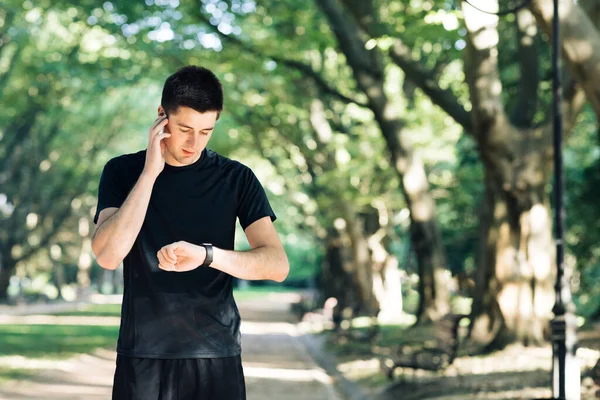 Akıllı saat kullanan bir koşucu. Antrenmandan sonra yakışıklı adam iz sürme sonuçları. Formda Adam 'ın portresi sonuçları kontrol ediyor. Sporcu adam akıllı görünüyor.
