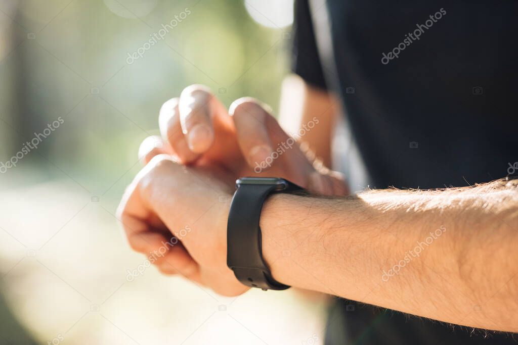 Smart watch. Smart watch on a mans hand outdoor. Mans hand touching a smart watch.