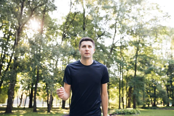 Hombre corriendo por la carretera en el parque de la ciudad. Personas de negocios urbanas formación fuera de disfrutar de la naturaleza fresca. Vida activa saludable. Mañana soleada de verano. Distancia deporte aplicación — Foto de Stock