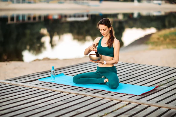 Sporcu kadın Tibet çanıyla meditasyon yapıyor.