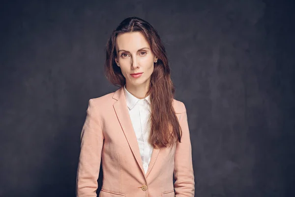 Koyu arkaplanda konsantre beyaz kadın.