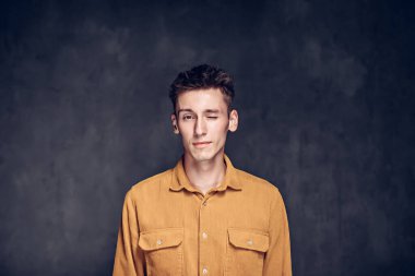 Siyah arka planda göz kırpan beyaz bir adam.