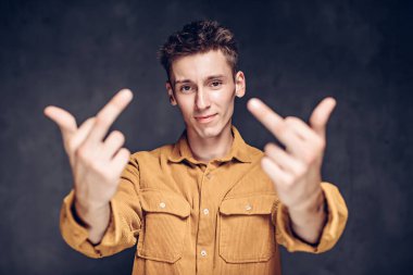 Genç adam arka planda orta parmaklarını göster