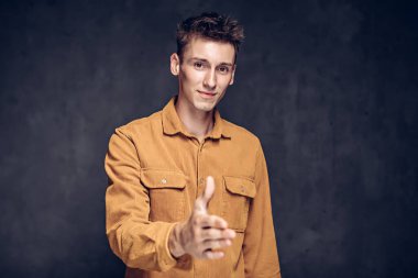 Beyaz adam koyu arkaplanda el sıkışıyor.