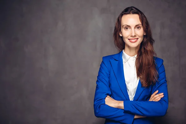 Koyu arkaplanda çapraz kolları olan gülümseyen kadın.