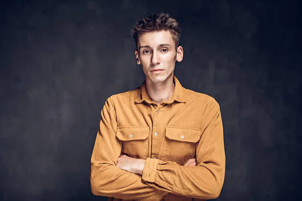 Caucasian man with crossed arms on dark background — Stock Photo, Image