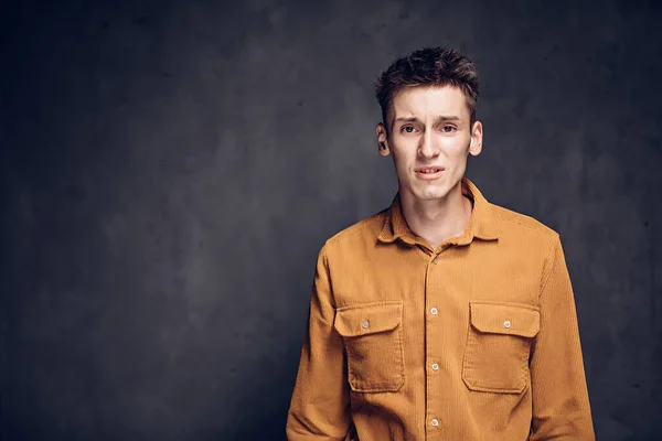 Tense young caucasian man on dark background — Stock Photo, Image