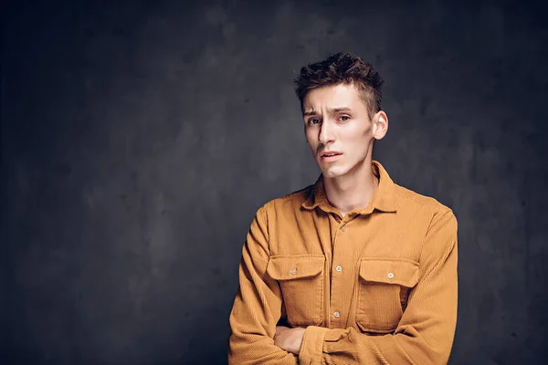 Upset young caucasian man on dark background — Stock Photo, Image