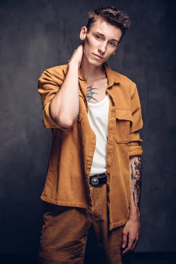 Esmer arka planda kendine güvenen beyaz bir adam.