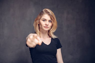 Genç beyaz kadın parmağıyla işaret ediyor.