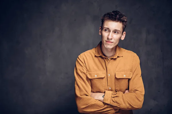 Sly young caucasian man on dark background — Stock Photo, Image