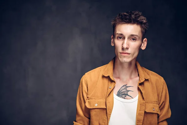 Esmer arka planda odaklanmış beyaz bir adam.