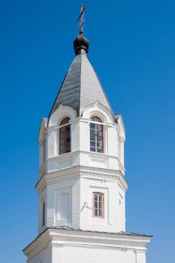 Beyaz taş Windows ile kule. Metal bir kubbe ve bir haç kilise kulesi.