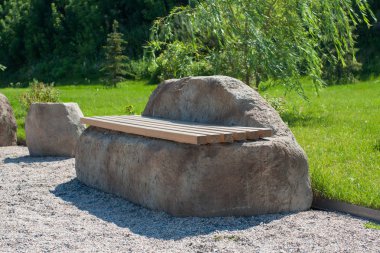 Parkta yeşil yaz çim. Taş ve ahşap Bank.