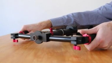 Bilinmeyen mühendis video tahta bir masanın üzerinde yatan çekim için üç eksenli manuel stabilizatör onarıyor. Çekim için kavram geliştirme ve onarım Kulesi