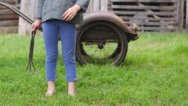 Pequena criança agricultor descalça fica na grama verde — Vídeo de Stock