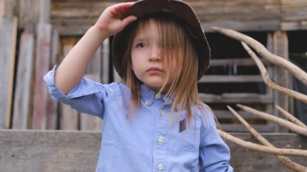 Beautiful little girl posing in a vintage helmet in her farm — Stock Video