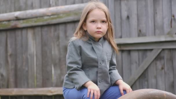 Retrato de una hermosa niña granjera sentada en el patio — Vídeos de Stock