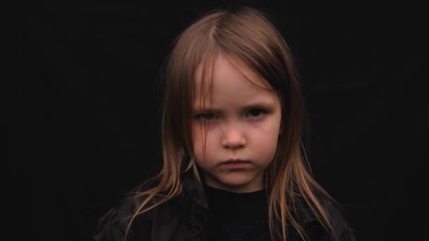 Portrait en gros plan d'une petite fille mignonne et sérieuse en vêtements noirs — Video