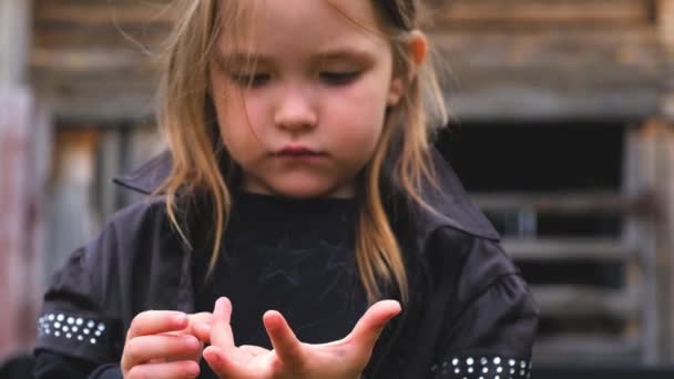 Close-up portret van een schattig klein meisje in zwarte stijlvolle kleding — Stockvideo