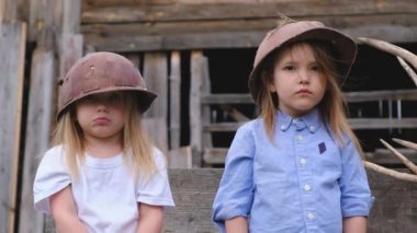 İki ciddi küçük kız bahçede duran kask binada poz 